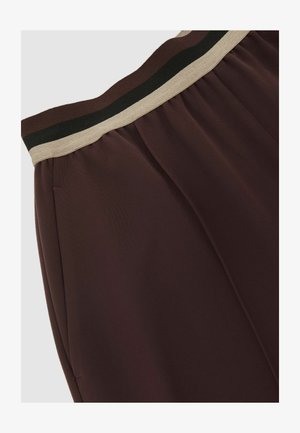 Bordové nohavice z mäkkého materiálu s elastickým pásom v čiernych a béžových pruhoch a skladaným dizajnom pre väčšiu textúru.