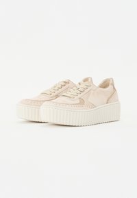 Baskets beige clair avec une tige en cuir lisse, semelle plate-forme surélevée et accents de couture contrastants. Présente un design à lacets et un col rembourré.