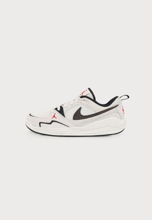Biało-czarny niski sneaker Nike Air Jordan z czerwonymi logo i siateczkową tkaniną na jednolitym jasnym tle.