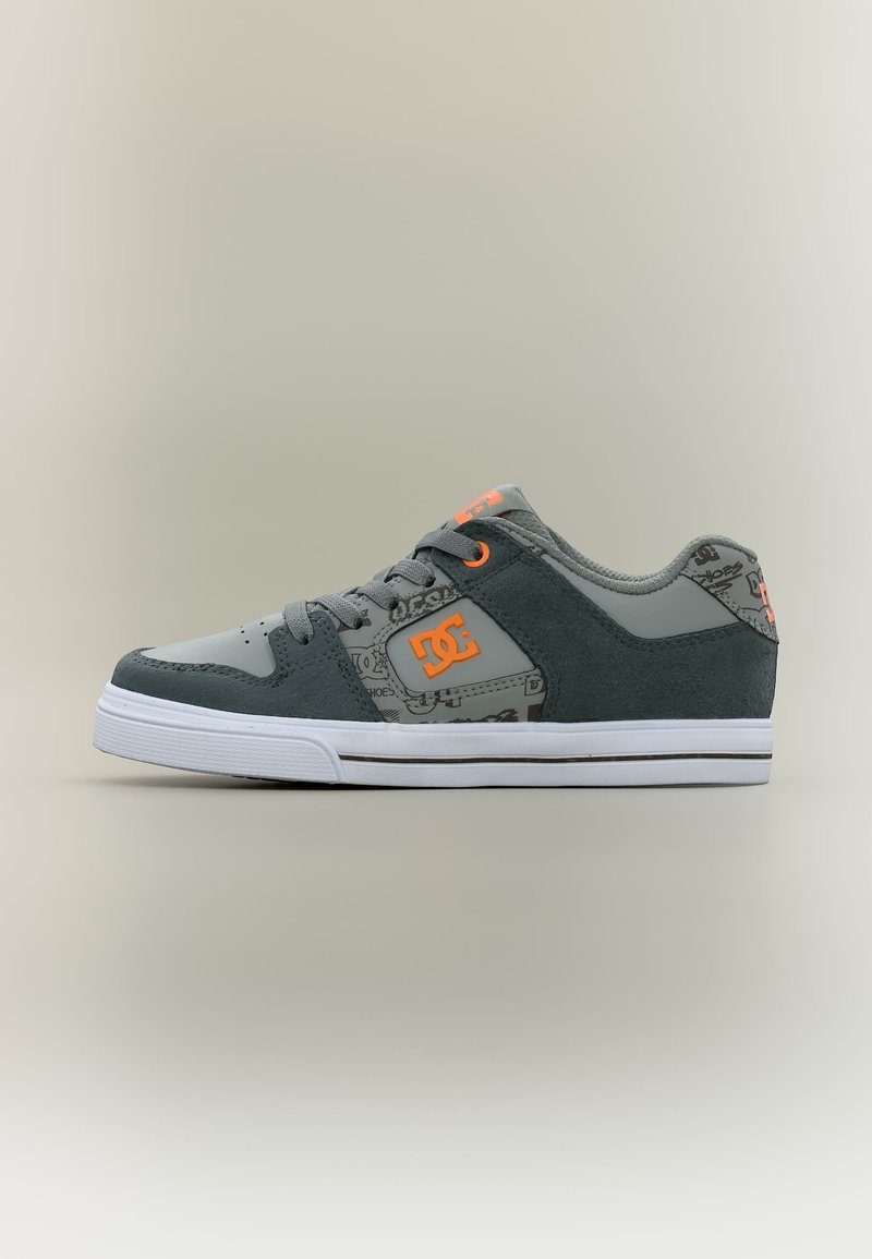 Chaussure de skate grise et noire avec logo DC orange, panneau latéral à motifs, lacets noirs et semelle blanche sur fond neutre.