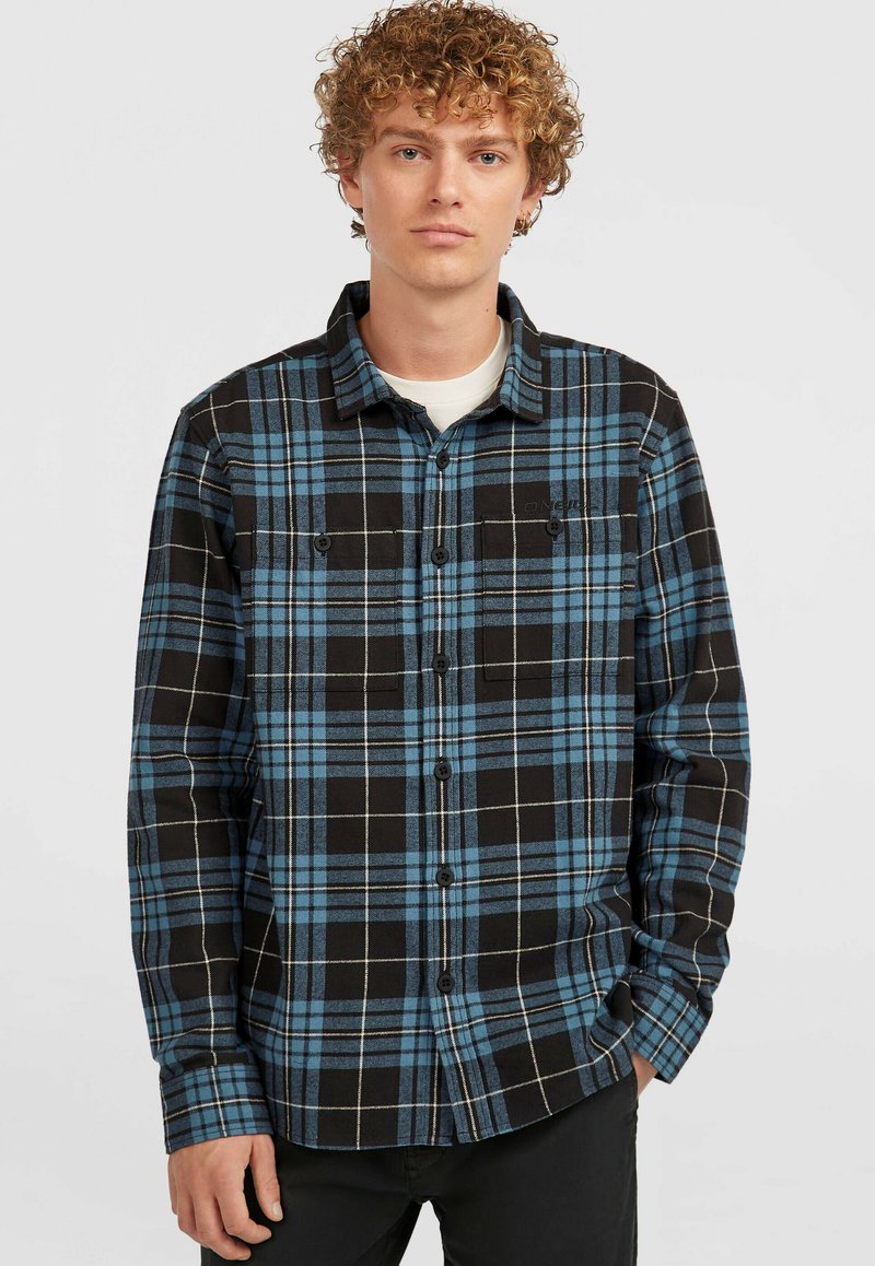 Camisa de cuadros en azul y negro, con cuello, cuenta con un bolsillo en el pecho y botones negros, hecha de una tela suave y texturizada.
