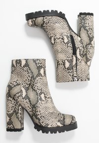 Bottes chevilles à imprimé serpent avec talon bloc haut, cuir texturé, fermeture éclair latérale, et semelle extérieure en caoutchouc robuste pour une bonne adhérence.