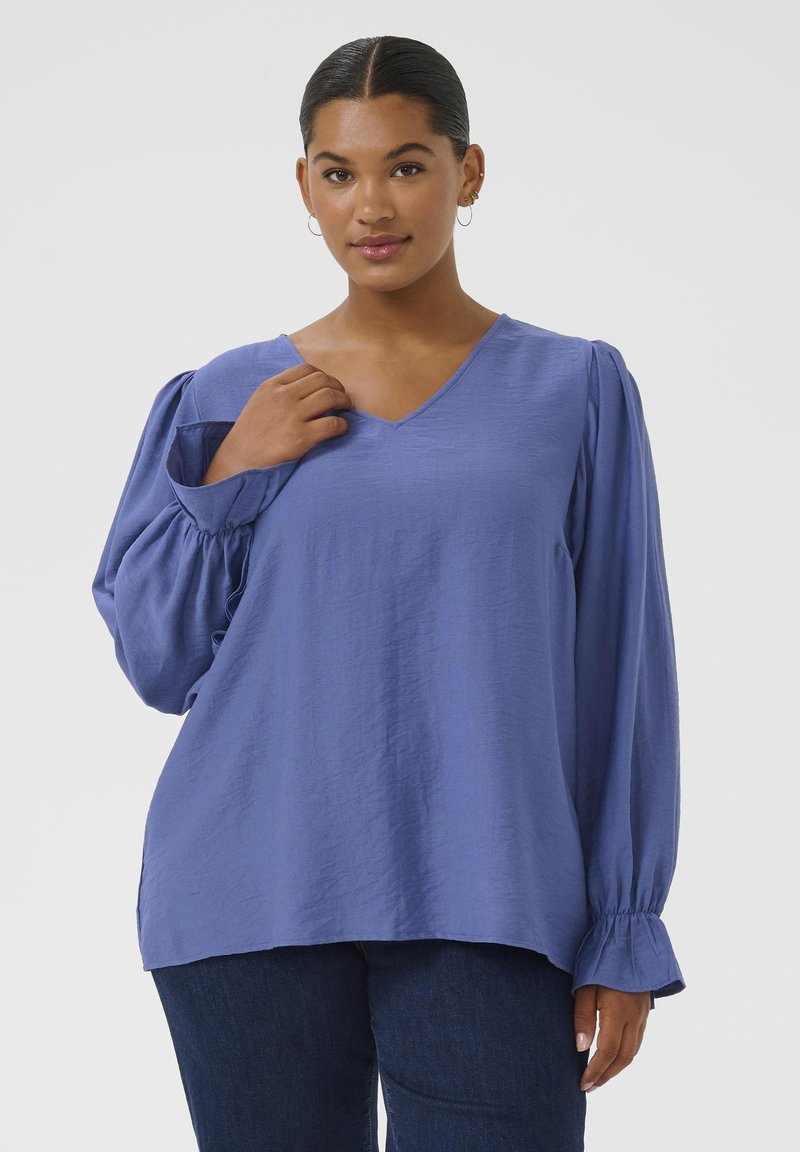 Blue V-neck blouse with puffed long sleeves and ruffled cuffs, made from a lightweight fabric, featuring a relaxed fit and smooth texture.
