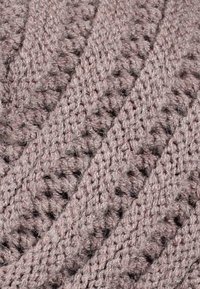Chunky knit fabric in muted mauve with textured, diamond-patterned design and open stitches, showcasing a soft, wool-like appearance.