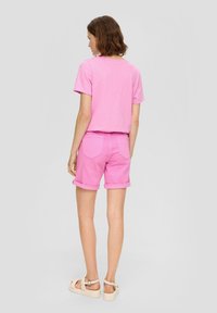 Roze katoenen T-shirt en bijpassende shorts, met omgeslagen zomen en een relaxte pasvorm. Lichte textuur met een eenvoudig ontwerp en geen zichtbare patronen.