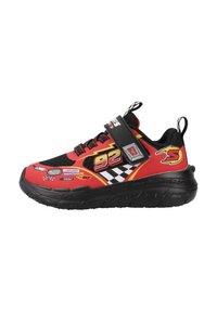 Zapatilla roja y negra con parte superior de malla, gráficos de carreras, correa de Velcro y suela de goma texturizada; presenta patrones de cuadros y acentos de logo.