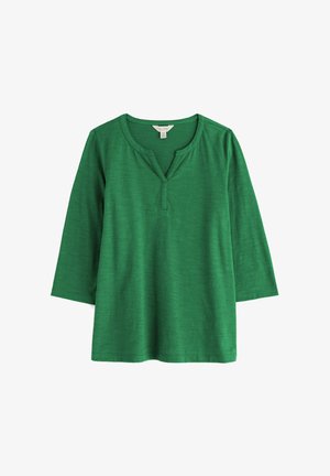 Groen shirt met driekwart mouwen en een inkeping in de hals, gemaakt van zacht, gestructureerd stof, plat weergegeven op een witte achtergrond.