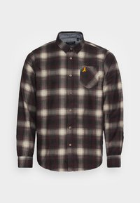 Koszula flanelowa w ciemnym bordowym i kremowym kratę. Posiada kieszeń na piersi z żółtym akcentem oraz brązowe guziki. Długie rękawy.