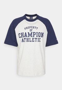 Šedé a námornické raglánové tričko, s bílým textem "VLASTNICTVÍ CHAMPION ATHLETIC," s krátkými rukávy a designem s kulatým výstřihem.