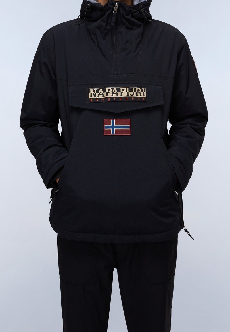 Anorak noir avec une poche à l'avant, présentant un logo texturé et un petit écusson du drapeau de la Norvège. Comprend une capuche avec cordon de serrage et des fermetures éclair.