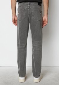 Grijze denim jeans met een rechte pasvorm, voorzien van twee achterzakken en subtiele vervaging. Afgerond met opgerolde manchetten en standaard riemlussen.