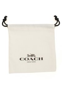 Vit bomullssnoddväska med svart snodd och tryckt "COACH NEW YORK"-logotyp. Slät textur med minimalistisk design.