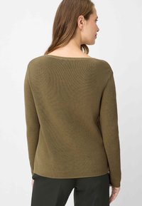 Olivgrüner Rippenstrickpullover mit weiterem Ausschnitt, langen Ärmeln und lockerem Sitz, mit subtiler horizontaler Struktur.