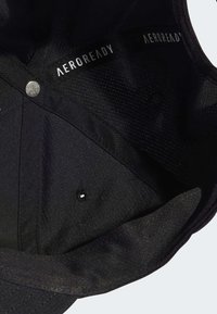 Gorra negra con interior de textura de malla, que presenta un cierre metálico redondo y una etiqueta "AEROREADY". Tejido suave y sin patrones visibles.