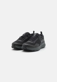 Schwarze Sportschuhe mit einem strukturierten Mesh-Obermaterial, gepolstertem Kragen und einer robusten Gummisohle mit multidirektionalen Stollen für bessere Traktion.