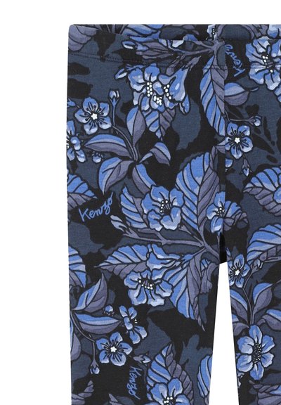 Leggings floraux avec un fond bleu foncé et des fleurs bleu clair et blanches. Comprend des feuilles vertes et un logo de marque subtil à l'ourlet.