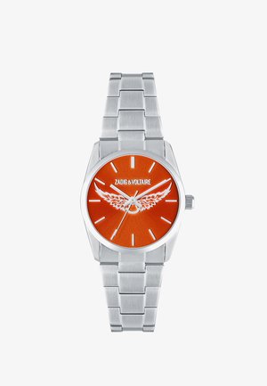 Reloj de pulsera de metal plateado con esfera naranja, emblema de ala blanca, marcadores de horas minimalistas y el logo "ZADIG & VOLTAIRE" en la parte superior central.