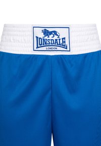 Mėlynos sportinės šortai su balta elastinga juosta. Viduryje yra prekės ženklą žymintis etiketė su užrašu "Lonsdale London" ir liūto logotipu.