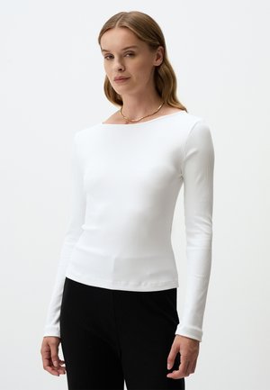 Witte lange mouwen ribbeltop met een ronde halslijn, met een slim fit en een soepele textuur, gecombineerd met zwarte broek. Eenvoudig ontwerp.