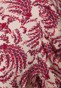 Tessuto a motivo floreale con intricati disegni rossi e blu su sfondo beige, con una texture liscia, leggera e una caduta morbida.