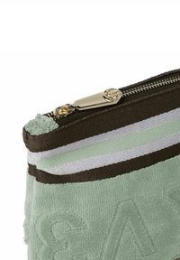 Bolsa de algodón mezclado en verde claro, con franjas marrones y menta, con letras en relieve y un cierre dorado con tirador decorativo.
