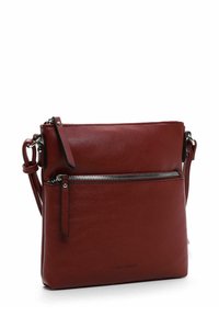 Rote Leder-Umhängetasche mit einer Reißverschluss-Vordertasche, verstellbarem Tragegurt und glatter Textur. Minimalistische Hardware und ein simples Design.