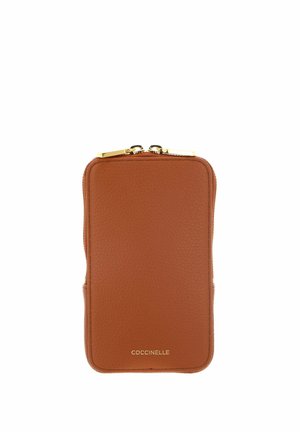 Portefeuille en cuir texturé marron avec fermeture éclair dorée et logo "COCCINELLE" embossé en or en bas au centre.