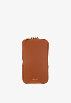 Portefeuille en cuir texturé marron avec fermeture éclair dorée et logo "COCCINELLE" embossé en or en bas au centre.