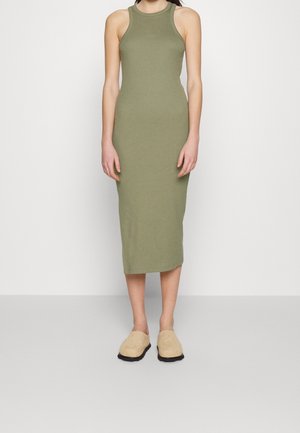 Olivgrünes, ärmelloses Midikleid mit taillierter Passform. Glatte Textur und runder Ausschnitt. Kombiniert mit beigen Slippers.