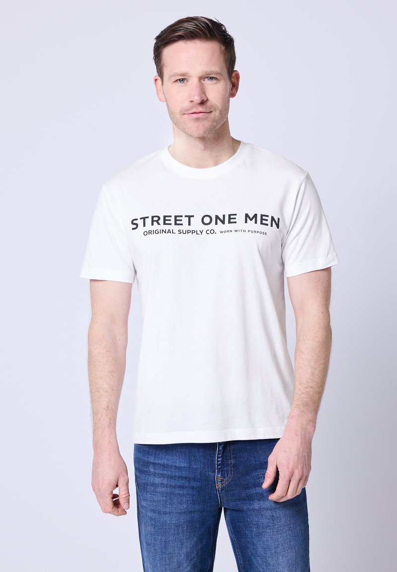 Biała bawełniana koszulka z czarnym napisem „STREET ONE MEN ORIGINAL SUPPLY CO. WORN WITH PURPOSE.” Krótkie rękawy, okrągły dekolt.