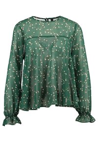 Blouse verte à motifs floraux avec manches longues, tissu transparent, poignets élastiques, encolure ronde, et motifs de fleurs blanches et roses dispersés.