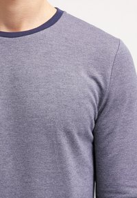 Maglietta grigia a maniche lunghe con collo rotondo blu navy, realizzata in un tessuto morbido e strutturato. Presenta un design fitted con dettagli di cucitura minimi.