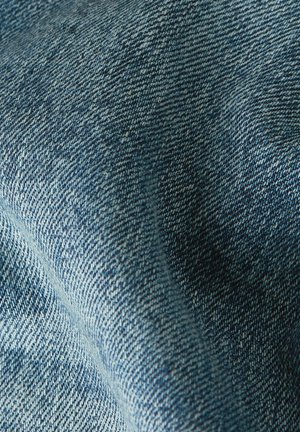 Makroaufnahme von blauem Denimstoff mit detailliertem diagonalen Webmuster und strukturierter Oberfläche.