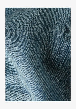 Makroaufnahme von blauem Denimstoff mit detailliertem diagonalen Webmuster und strukturierter Oberfläche.