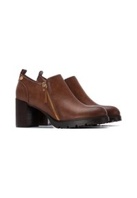 Botas de tobillo de cuero marrón con cremallera lateral, tacón cuadrado y suela de goma texturizada. Cuenta con herrajes dorados y un acabado suave.
