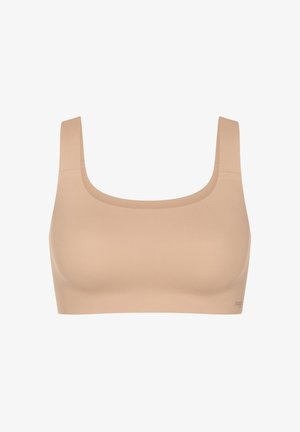 Seamless beige sports bra with wide shoulder straps and a square neckline, designed for comfort and support.
