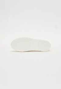 Talpa de sneaker alb cu un model de profil în zigzag. Prezintă un material de cauciuc neted, vârf rotunjit și o marcă minimă pe lateral.