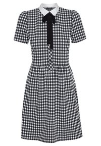 Mustassa ja valkoisessa ruutukuosissa oleva mekko, jossa on lyhyet puffihihat, valkoinen kaulus ja musta solmio, napitus edessä ja laskostettu hame.