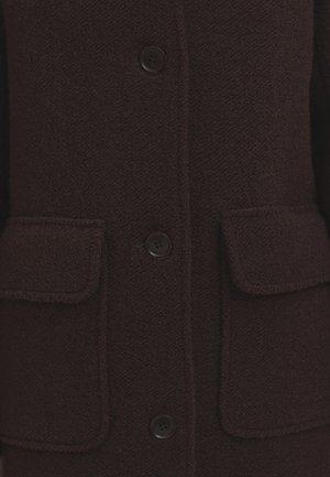 Manteau en laine marron foncé avec une finition texturée, quatre boutons noirs et deux poches avant à rabat avec des bordures cousues.