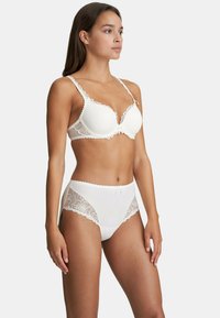 White lace-trimmed bra and matching high-waisted panty set. Smooth fabric with floral lace accents, scalloped edges, and soft texture.