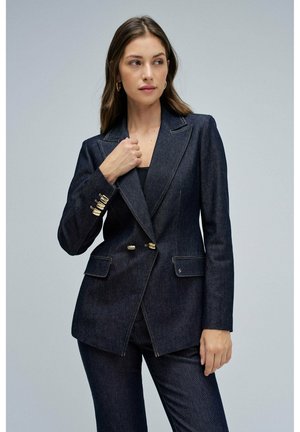 Blazer de denim oscuro con un corte ajustado, solapas con muesca, botones dobles dorados y bolsillos laterales. Tejido texturizado y forma estructurada.