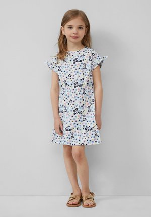 Robe florale avec des manches courtes et volantes, présentant un fond pastel clair et des fleurs bleu foncé, roses et vertes. Tissu léger et doux.