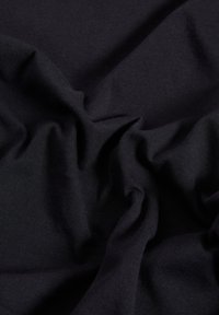 Tessuto di cotone blu scuro con una texture liscia, caratterizzato da pieghe morbide e arricciate, che creano un aspetto organico e fluido.