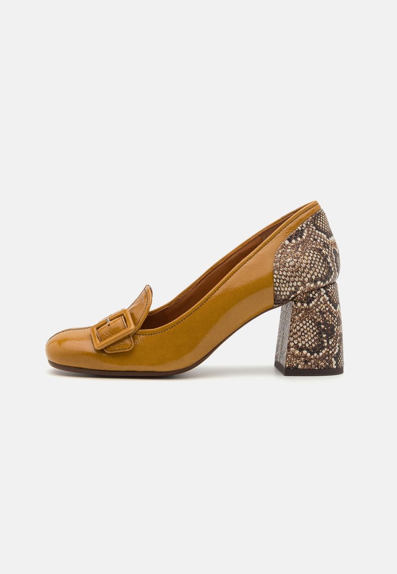 Chaussure à talon en cuir verni jaune moutarde avec une large boucle sur le devant et un talon en bloc au motif serpent.