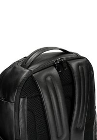 Czarny skórzany plecak o teksturowanym wykończeniu, z wyściełanymi siateczkowymi paskami, podwójnym zamknięciem na zamek błyskawiczny oraz smukłym designem, zapewniającym funkcjonalność.