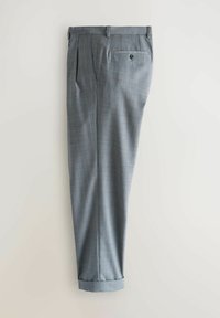 Pantalon gris sur mesure pour femme avec un motif à carreaux subtil, doté d'une poche arrière boutonnée et d'un ourlet retroussé.