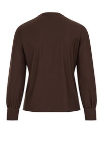 Brūns garroku tops no mīksta auduma. Piedurknes ir savāktas un ir brīvs piegriezums. No aizmugures redzama gluda tekstūra un vienkāršs dizains.