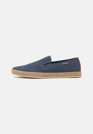 Enkelt navyblåt slip-on sko med perforeret overdel, beige vævet sål og lille brun hælkappe på ens hvid baggrund.