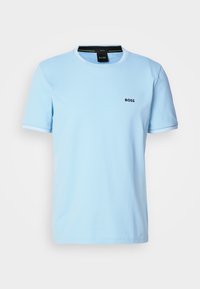 T-shirt bleu clair à manches courtes avec bordures blanches aux manches et au col, arborant un petit logo noir "BOSS" sur le côté gauche de la poitrine.