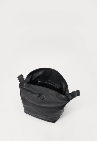 Black leather shoulder bag with a smooth texture, round magnetic closure, and a zippered pocket inside. Adjustable strap included.